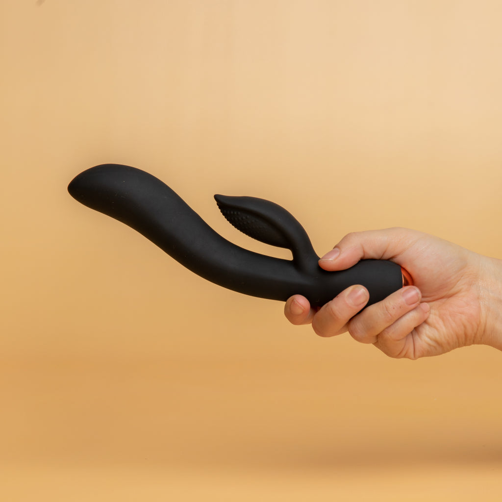 A hand holding the regala rabbit, black colour. There is one length that is insertable, a shorter length for clitoral stimulation. This part is has ribbing to add extra sensation. 