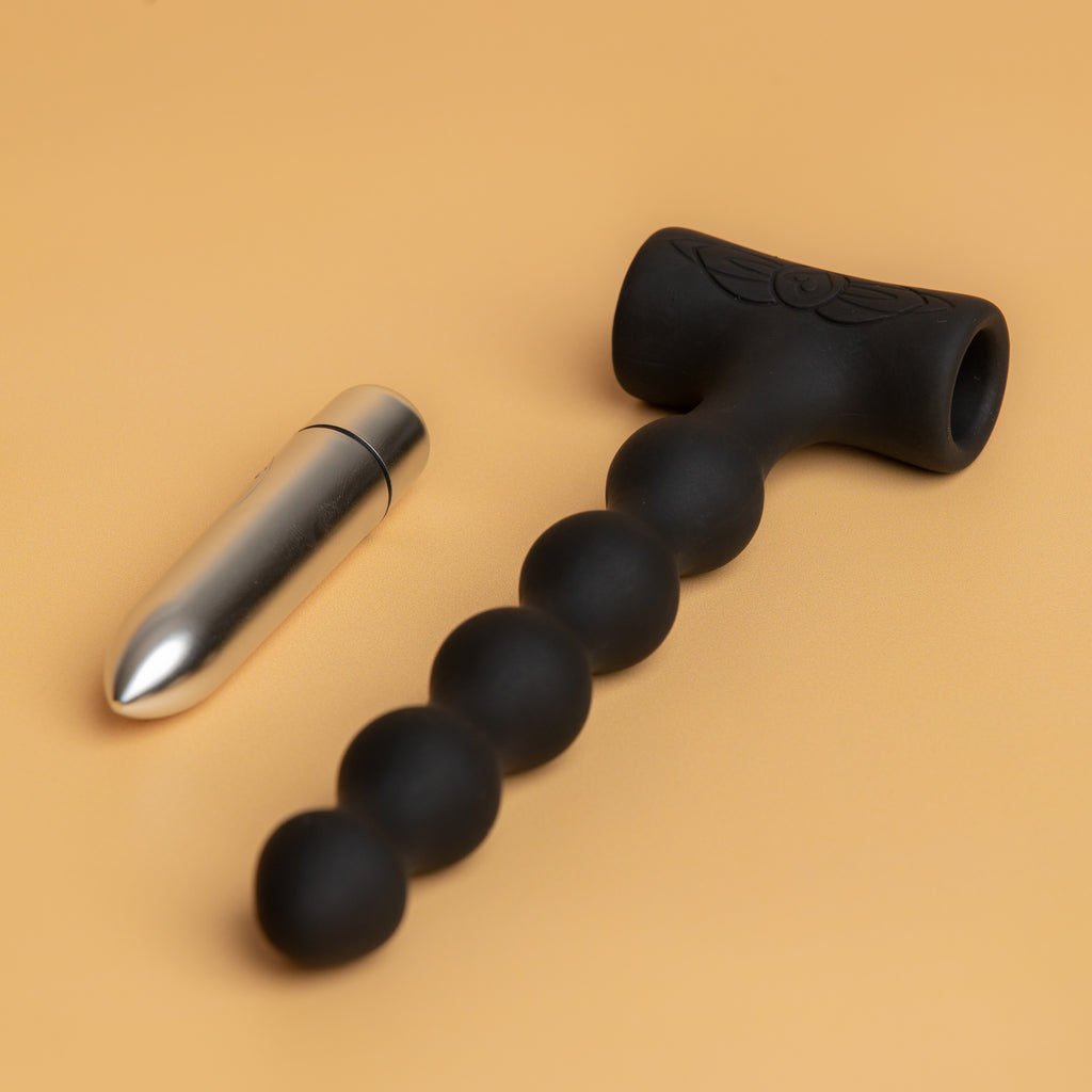 The black petite sensations with the removable vibrating bullet lying next to it. sold at xesproducts.com.au xes products