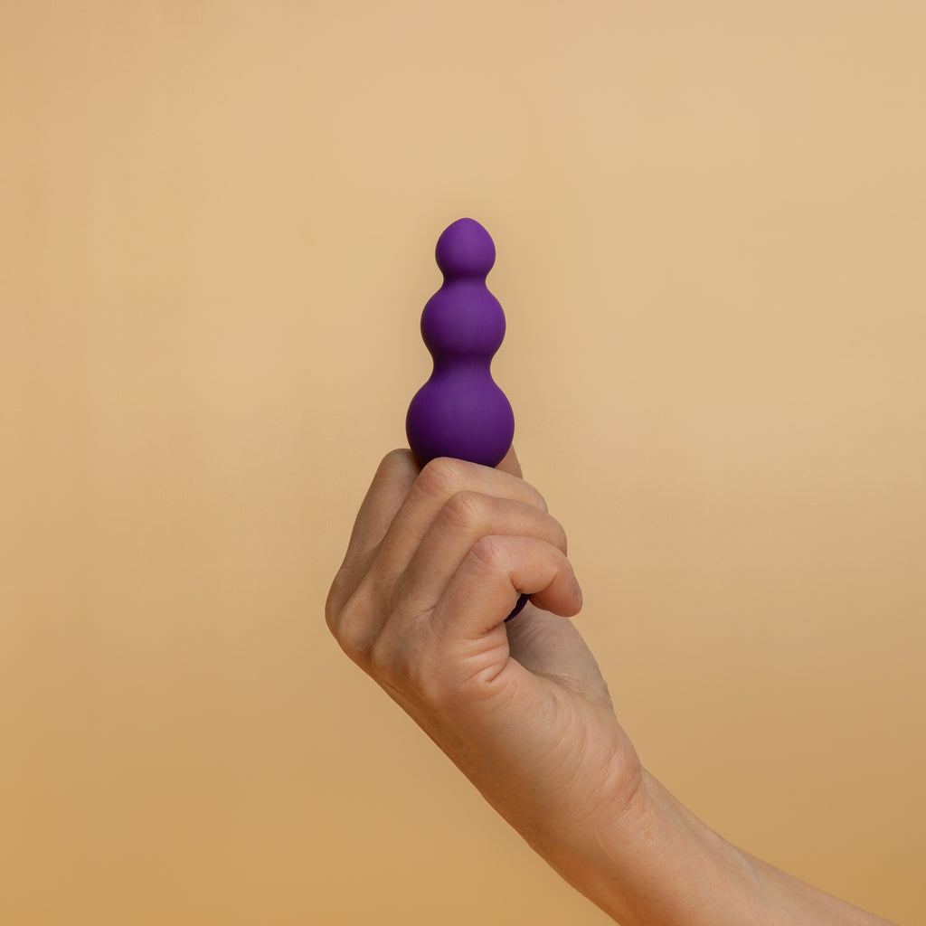 A person holding the petite sensations bubbles in purple. You can see the three graded bubbles. 