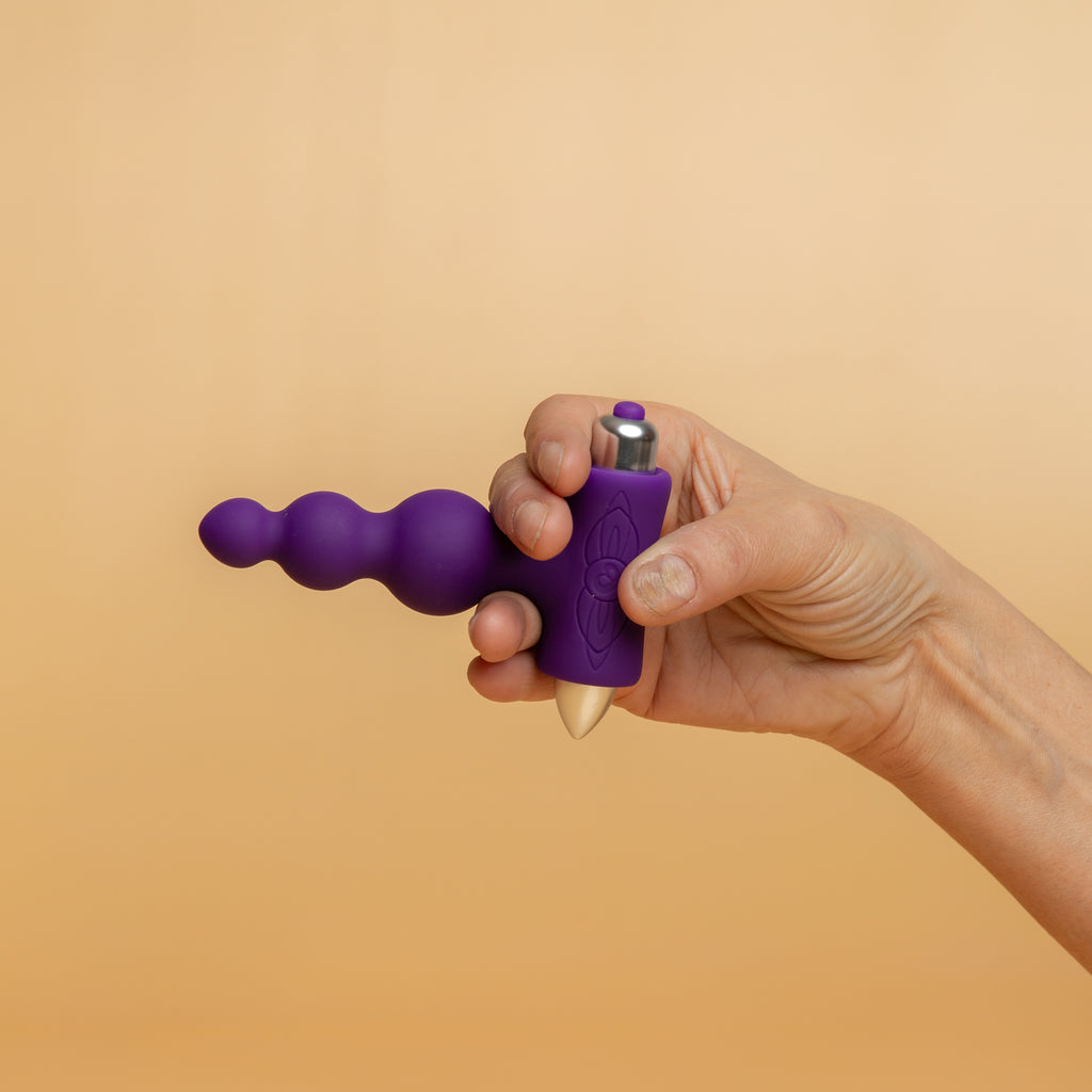 A hand holding the petite sensations bubbles in purple. 