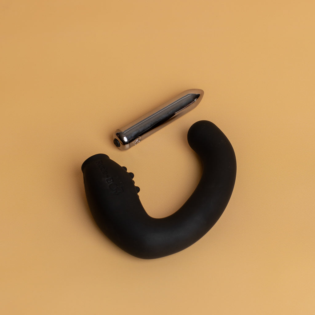The rude boy shape is curved like a wide C shape.  Towards the non insertable end of the vibrator there is dotted ribbing to add extra sensation to the prostate. The bullet is removed. One end is pointed while the other has the button to turn the bullet on and off