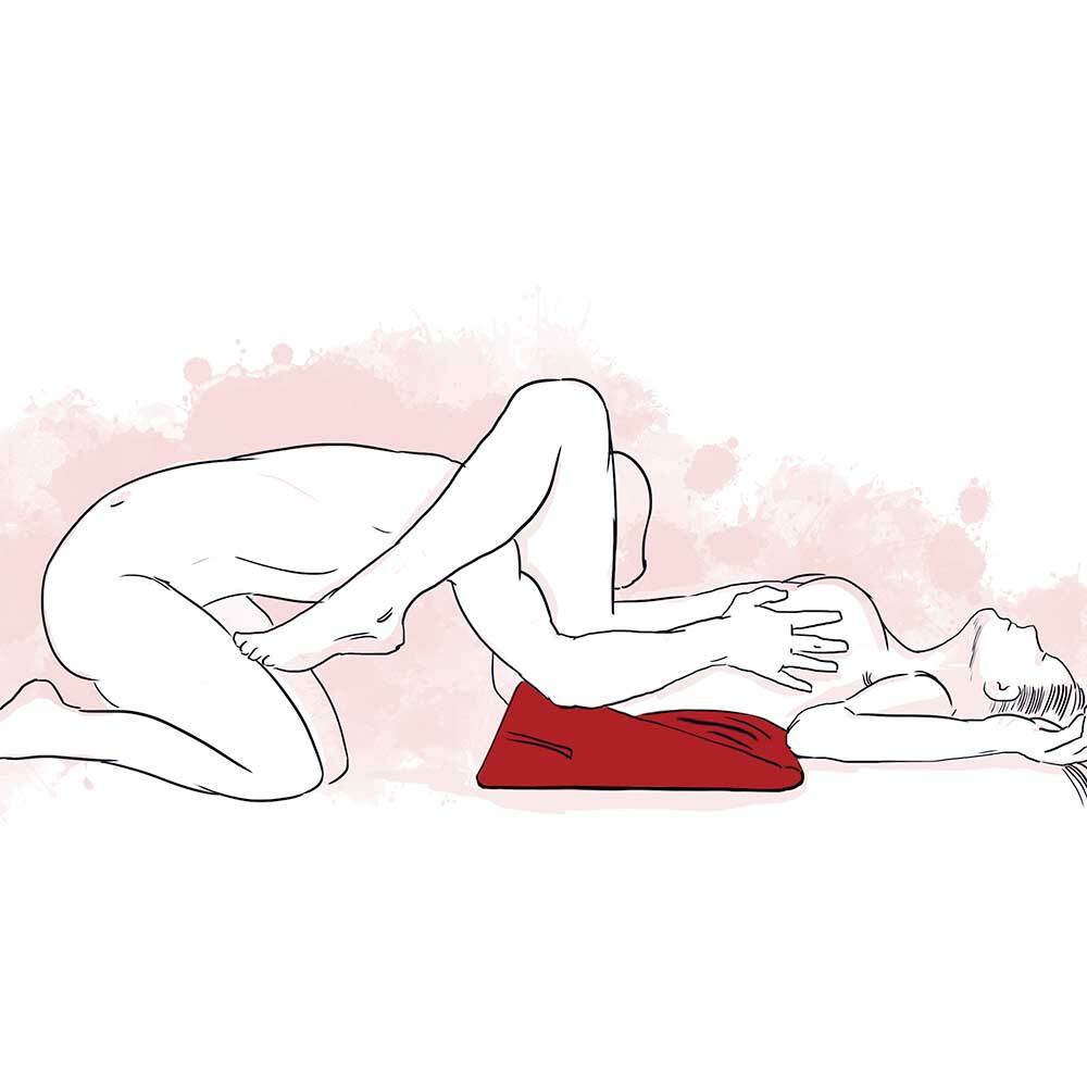 A woman lying on her back with her bottom supported by the wedge (red). The partner is giving cunnilingus while on their knees. 